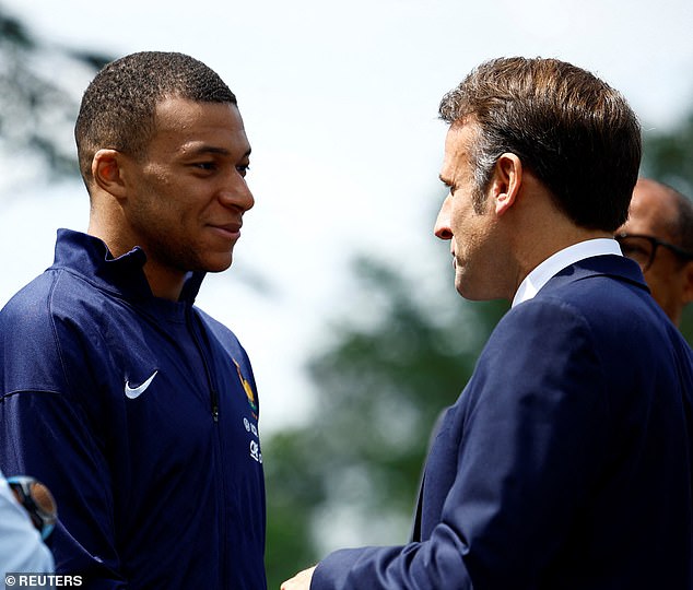 Macron (right) shakes hands with footballer Kylian Mbappe (left)