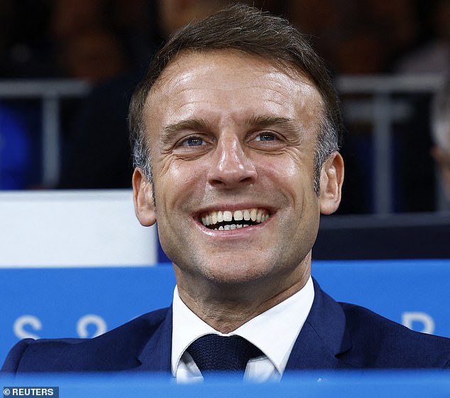 French President Emmanuel Macron smiles as the opening ceremony takes place