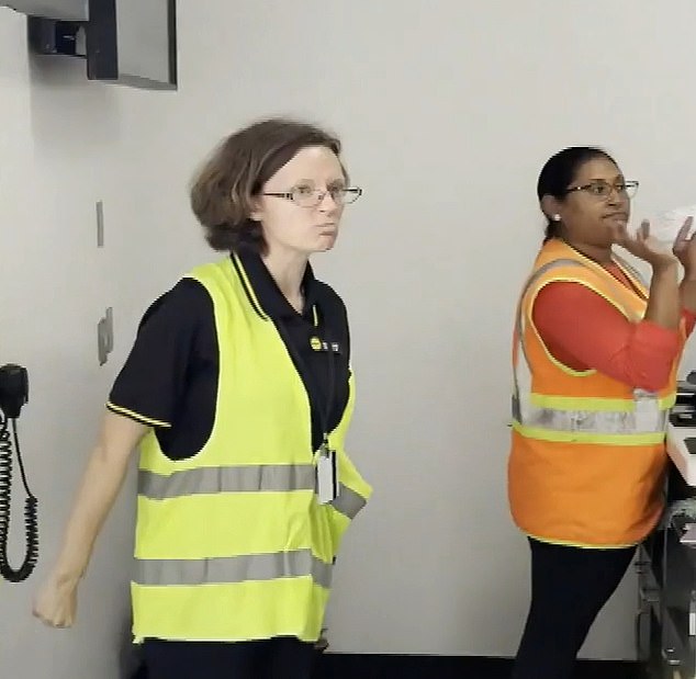 An angry Spirit Airlines gate agent is seen clenching her fists and frowning before yelling at a group of passengers waiting to board a flight