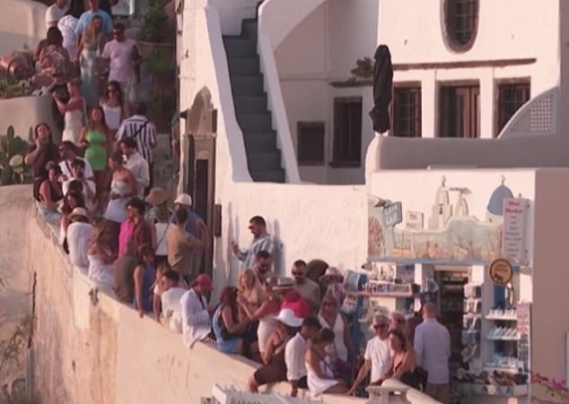 Furious locals have threatened to leave Santorini after officials ordered them to stay away from the thousands of tourists (some pictured above this month) who travel to the tiny island every day