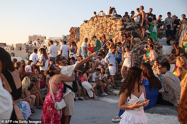 Hundreds of tourists gather in the village of Oia on Santorini to watch the sunset on July 20.