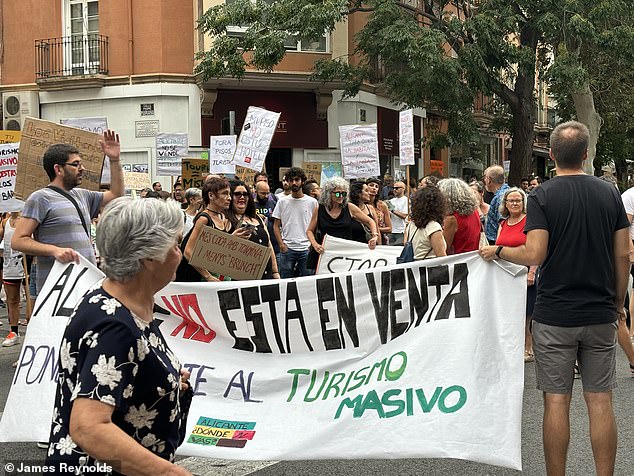 A banner is held aloft during a march against overtourism in Alicante earlier this month