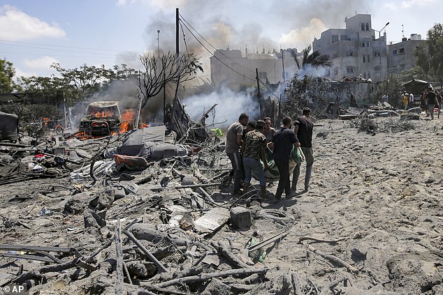 Palestinians evacuate a body from a site hit by an Israeli bombardment in Khan Younis, southern Gaza Strip, on July 13