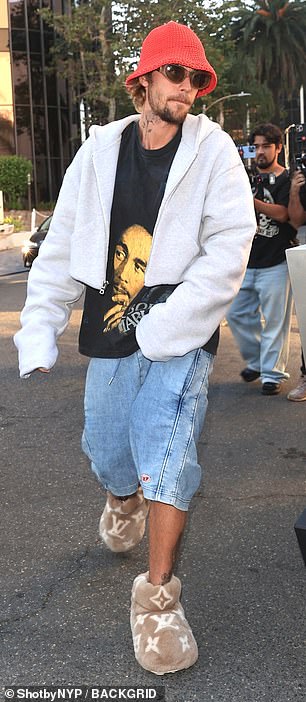 Her husband Justin went for a much more casual, sloppy look with a red knitted bucket hat and a cropped gray zip-up hoodie