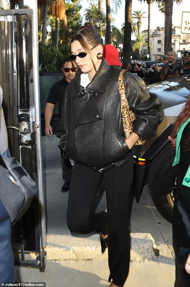 Hailey contrasted her monochrome ensemble with a cheetah print handbag and added some sparkle with statement round gold earrings with black frames