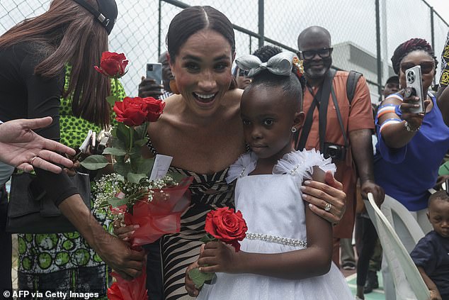 Meghan receives flowers from a girl upon arrival for a sitting volleyball match in Abuja on May 11