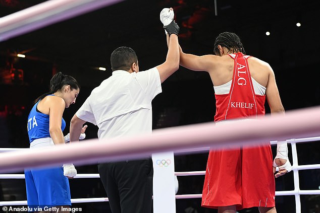 The judge holds up Khelif's arm, symbolizing her victory over Carini