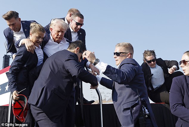 Republican presidential candidate and former President Donald Trump is led off the stage during a rally on July 13, 2024