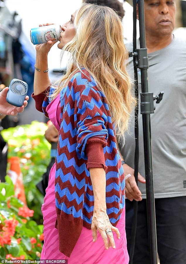 In between takes, she could be spotted cooling herself off in the summer heat with a sip of sparkling water, while a crew member held a fan towards her