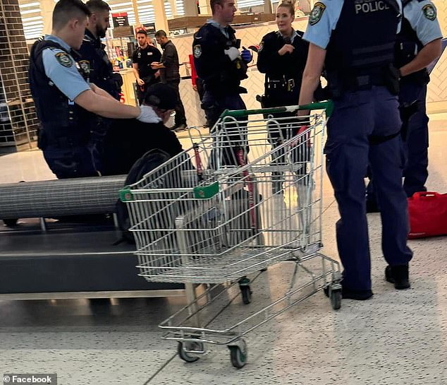 Photos from the scene showed a seated man with officers surrounding him at Chullora Marketplace