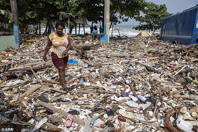 A woman walks along Manresa beach, covered in trash after the passage of Hurricane Beryl, in Santo Domingo, Dominican Republic, July 3, 2024