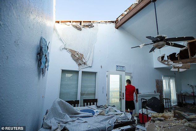 A contractor inspects a Dallas client's home for structural damage after Hurricane Beryl tore through the area in Galveston, Texas on July 8, 2024.