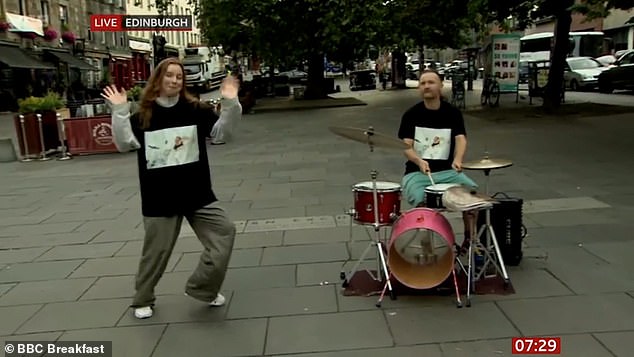 A duo performed a show in the empty street, with one half of the couple playing the drums loudly and the other half dancing quietly in the background