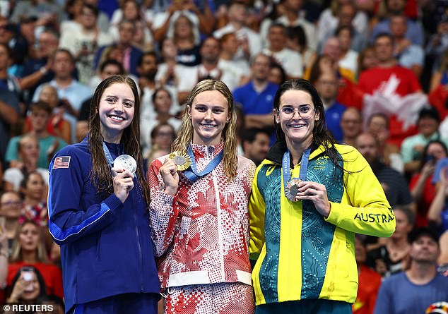 Canadian superstar Summer McIntosh (center) won gold, while American Kate Douglass (left) won silver - but her compatriot Alex Walsh was stripped of her third place by the judges