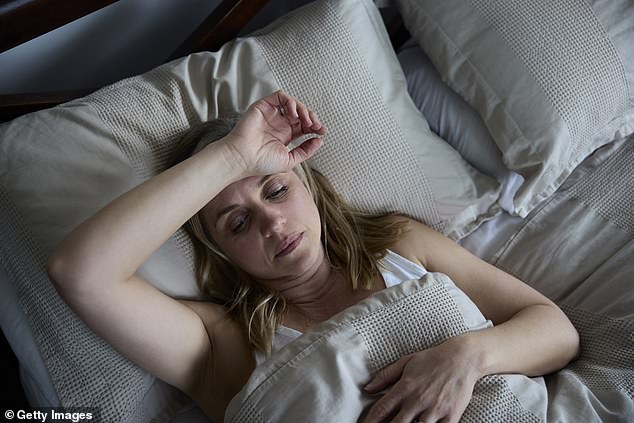 Adult menopausal woman suffering from insomnia in bed at home