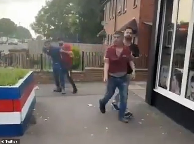 In the 25-second clip, a group of youths can be seen gathering around a man and beating him. A man in a red top is pulled away from the group by a second man in light-colored pants and a dark top