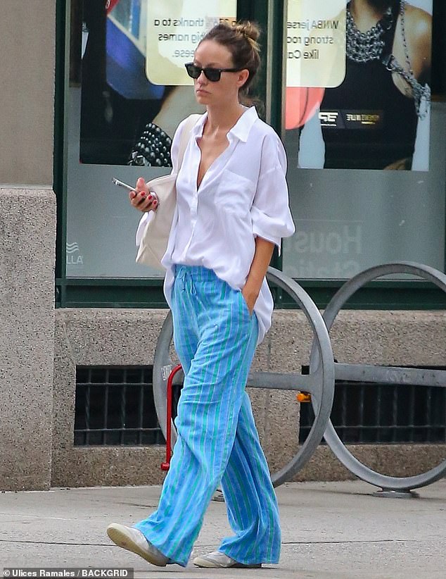 For her grocery run, the 40-year-old Don't Worry Darling director donned a loose white button-down shirt and blue drawstring pants