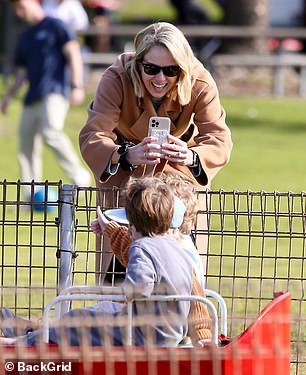 She held her phone as her boys posed for the camera