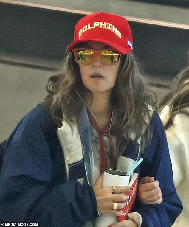 Drew appeared to be makeup-free during her long flight back to the US and wore reflective designer sunglasses