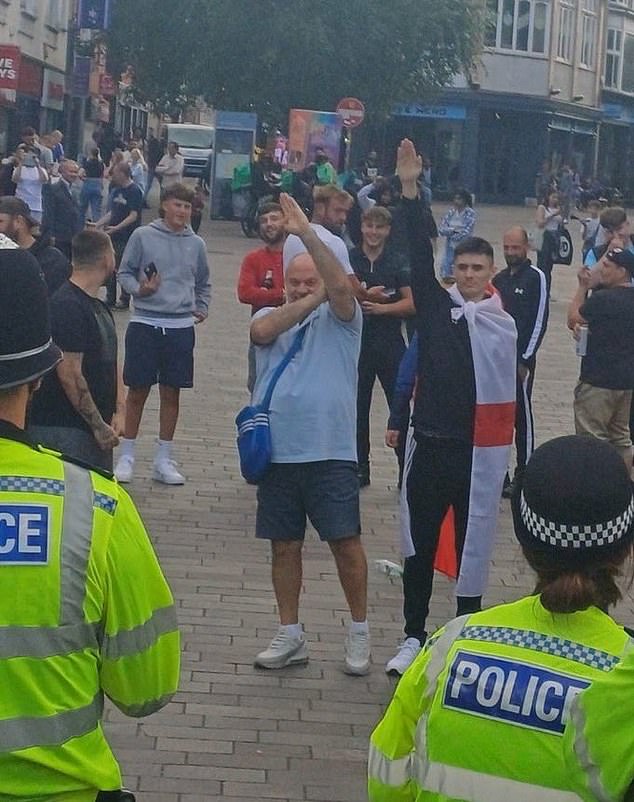 A group of men give the Hitler salute to police officers during a demonstration in Leicester