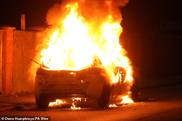 A police car burns as officers are deployed to the streets of Hartlepool following a violent protest on Wednesday