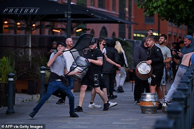 A person throws a chair in Bristol during violence on the streets of the southern city