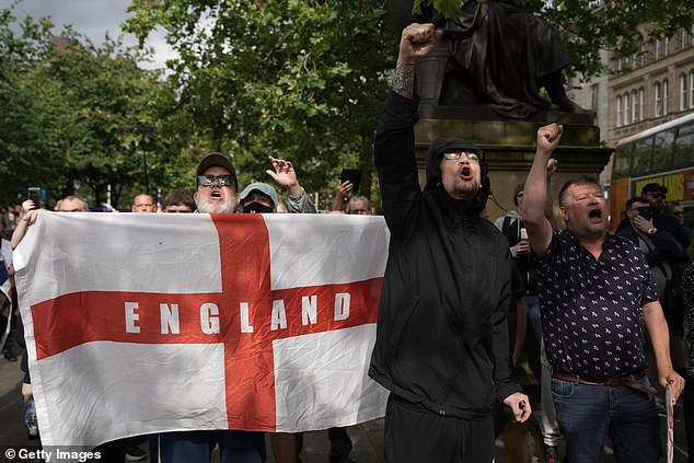 MANCHESTER: Activists take part in a protest in Piccadilly Gardens, holding an English flag