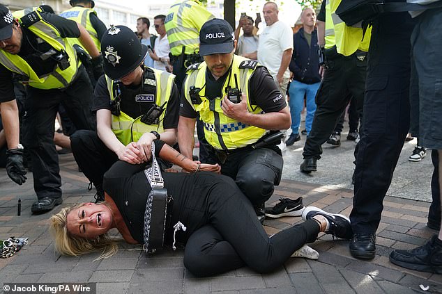 Police officers arrest a woman during a protest at Nottingham Market Square yesterday