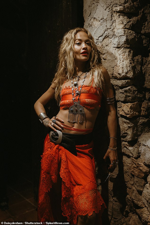 The 33-year-old wore an orange co-ord consisting of a crop top and a midi skirt with a crochet pattern along the hem, styled with a chunky black belt