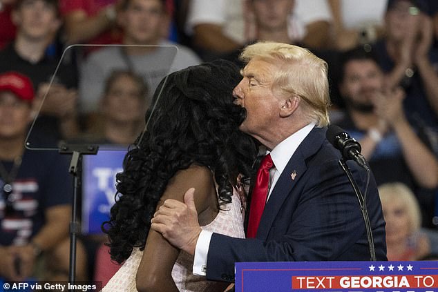 Trump kisses activist Michaelah Montgomery after bringing her onstage at his Atlanta rally