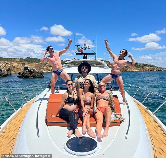 Tom showed off his toned body as he wore a pair of blue budgy smugglers while posing with Nicole and friends on the boat