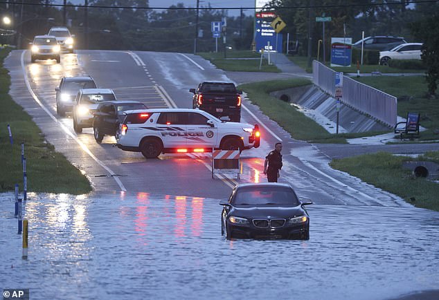 A BMW sedan is stuck in high water along South U.S. Alt 19 in Tarpon Springs, Florida, Monday morning, Aug. 5, 2024, as Hurricane Debby passes offshore of the Tampa Bay area