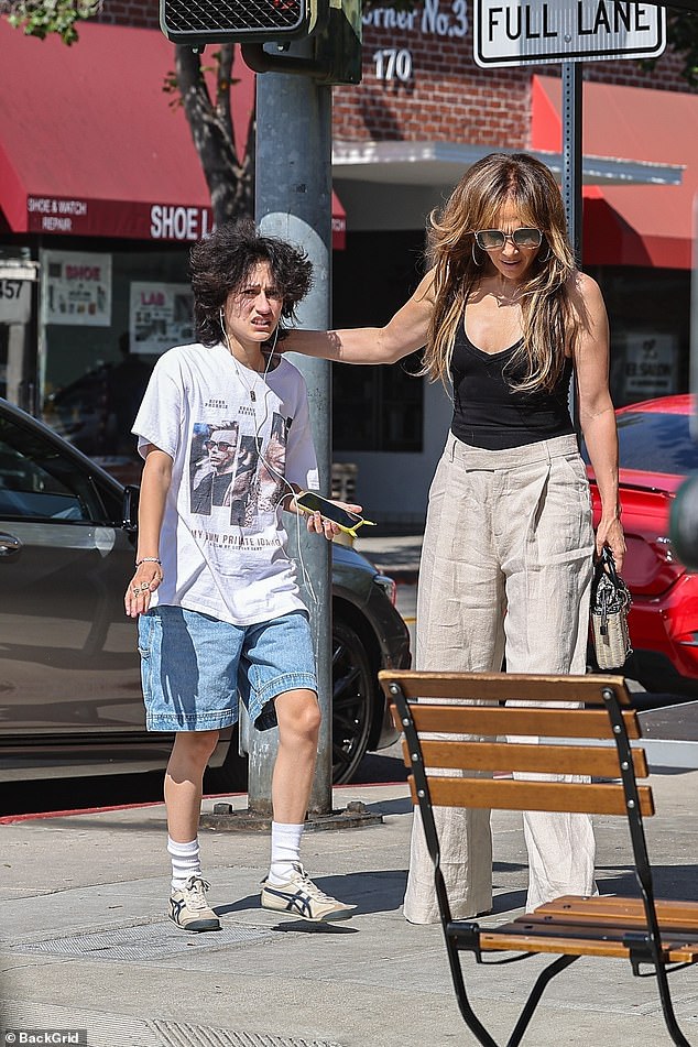 The star looked somber as she stepped out with 16-year-old Emme, wearing a plunging black top and high-waisted cream pants - after flying back to LA from a long stay in the Hamptons.