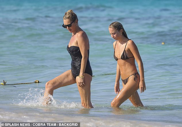 The model, 50, gave her age away in a striking £125 black Gottex bandeau swimsuit that accentuated her supermodel body as she lounged on the beach