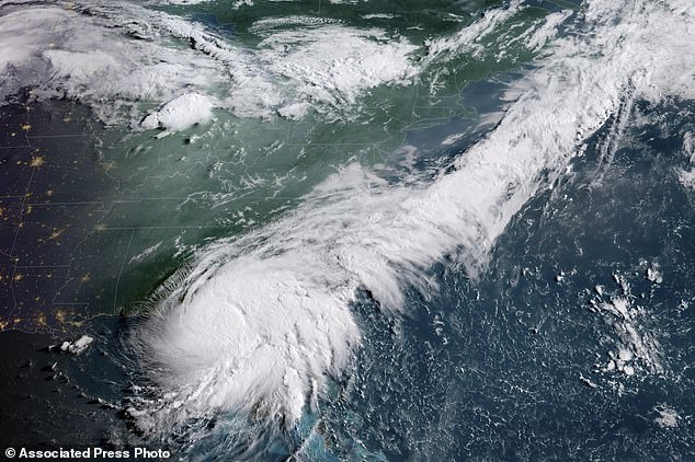 This GOES-16 GeoColor satellite image, taken at 8:16 a.m. EDT and provided by the National Oceanic and Atmospheric Administration (NOAA), shows Hurricane Debby, lower left, a Category 1 storm over northern Florida, Monday, Aug. 5, 2024.