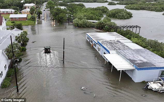 In an aerial view, a Florida National Guard vehicle drives through a flooded street due to rain and storm surge caused by Hurricane Debby on August 5, 2024 in Cedar Key, Florida.