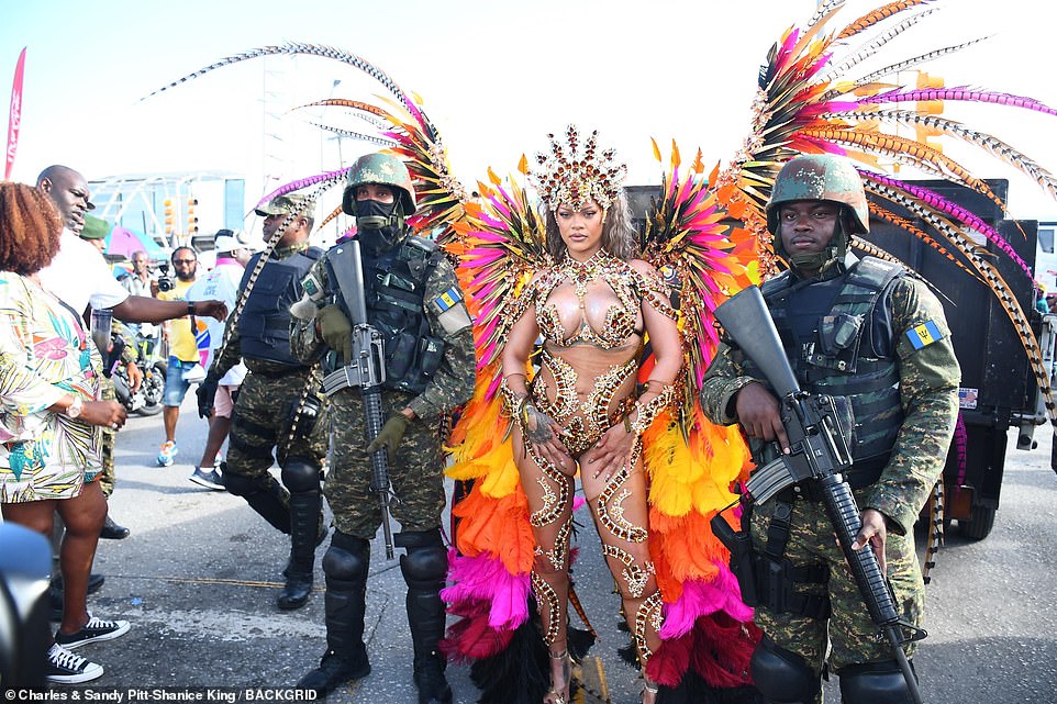 In a surprise move, Rihanna was flanked by armed soldiers carrying large assault rifles as she stepped outside to join the crowd