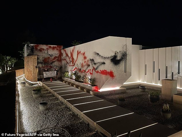 The climate group Futuro Vegetal has sprayed the white facade of the building with red and black paint