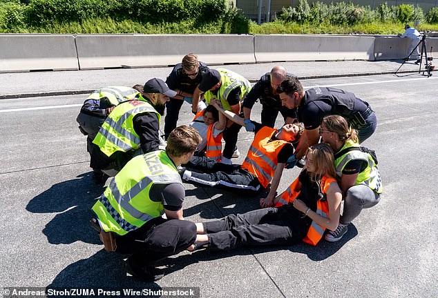 Climate activists from Last Generation Austria are taken away by police after gluing themselves to the A10 Autobahn towards Villach, disrupting Pentecost holiday traffic. Before the road was blocked, there was already a five-hour wait and a 10-mile traffic jam