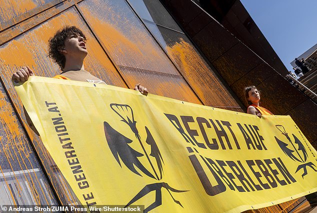 Climate activists from 'Last Generation Austria' spray the Vienna University of Economics and Business orange with a fire extinguisher