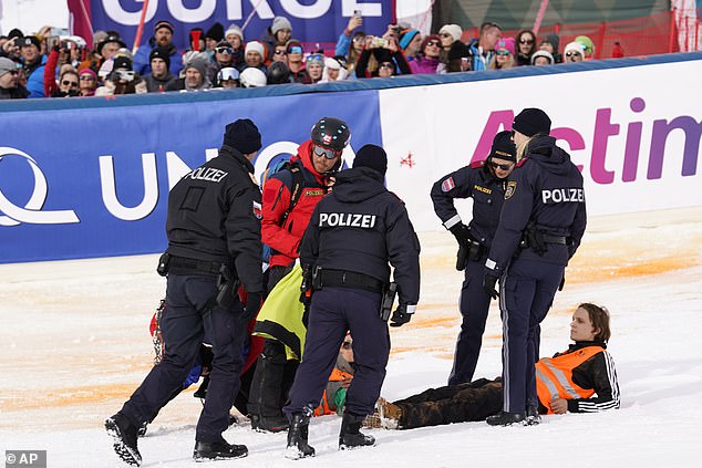 Activists from Last Generation are taken away after spray painting the finish area of ​​the men's World Cup slalom in Gurgl, Austria, Saturday, Nov. 18, 2023