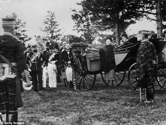 John Brown (centre in a kilt) stands beside Queen Victoria's carriage, preparing to alight at Windsor to inspect 52,000 volunteers, 1881. On the left is her son, the future King Edward VII.