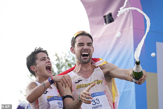 Spaniards Maria Perez and Alvaro Martin celebrate their victory in the marathon race walking relay during the 2024 Summer Olympics, Wednesday, Aug. 7, 2024, in Paris, France. (AP Photo/Vadim Ghirda)