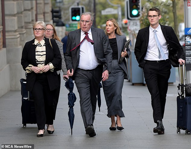 Linda Reynolds, pictured left, arrives at court on Monday with her lawyers. Martin Bennett stands next to Mrs Reynolds