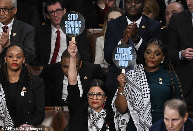 (L-R) U.S. Rep. Rashida Tlaib, Democrat of Michigan, and U.S. Rep. Cori Bush, Democrat of Missouri, hold signs reading 