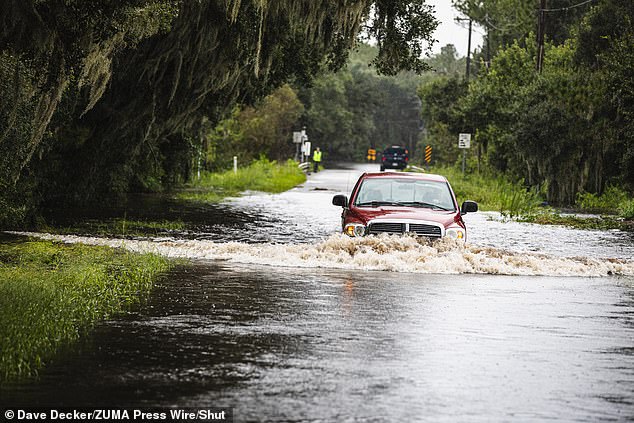 Residents of Wimauma, a rural part of Hillsborough County, Florida, drive through floodwaters of the Little Manatee River on August 5, 2024.