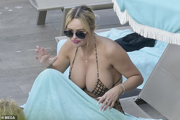 Ashley - who bears a striking resemblance to Pippen, 50 - showed off a fuller bust in a printed string bikini as she chatted while relaxing on a lounger