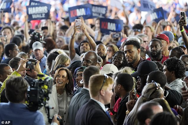 Kamala Harris takes pictures with the audience after her remarks