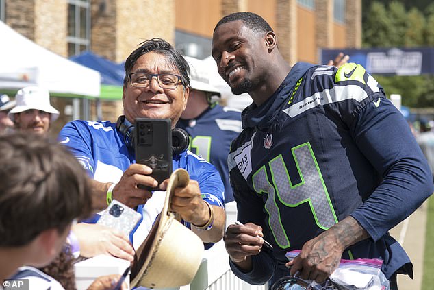 Metcalf poses for a photo with a fan after practice in Renton on Wednesday