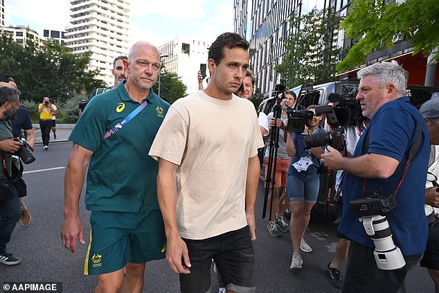 The 28-year-old is pictured with Australian hockey executive Bernard Savage (left) on his way to tell the media he had made a 